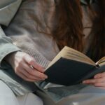 Serene scene of a woman reading a book outdoors, capturing a moment of tranquility and leisure.